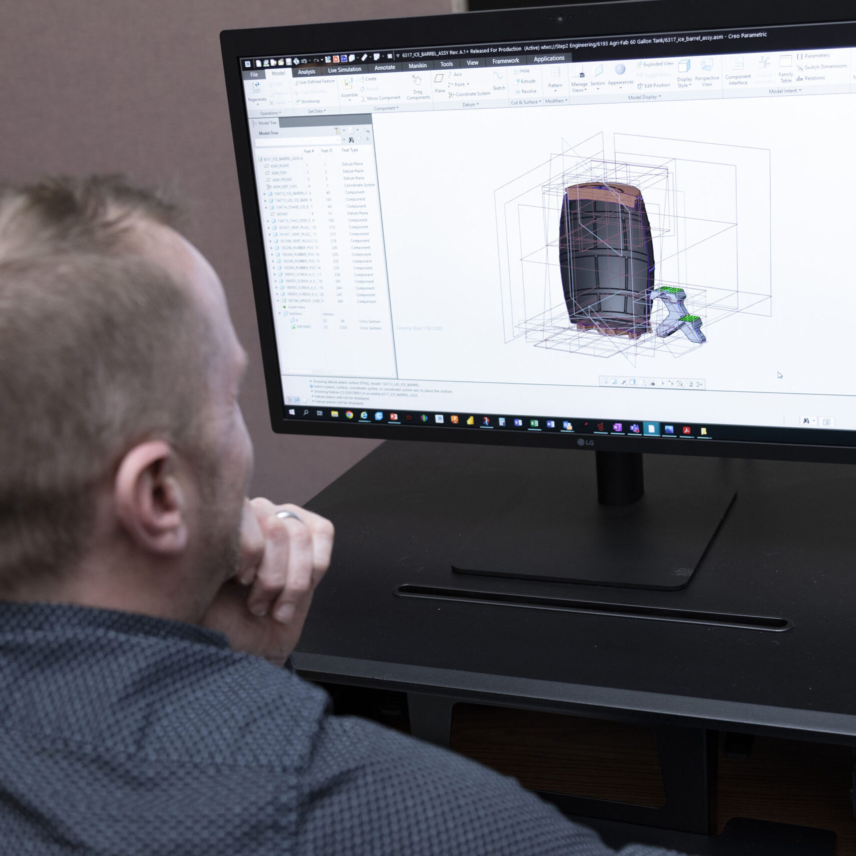 Man looks at a computer screen of the interior of an Ice Barrel product design.